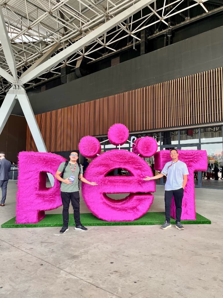 Equipe Veler ao lado do letreiro PET na PETSA 2026 — holding por trás do VoaPet no mercado pet